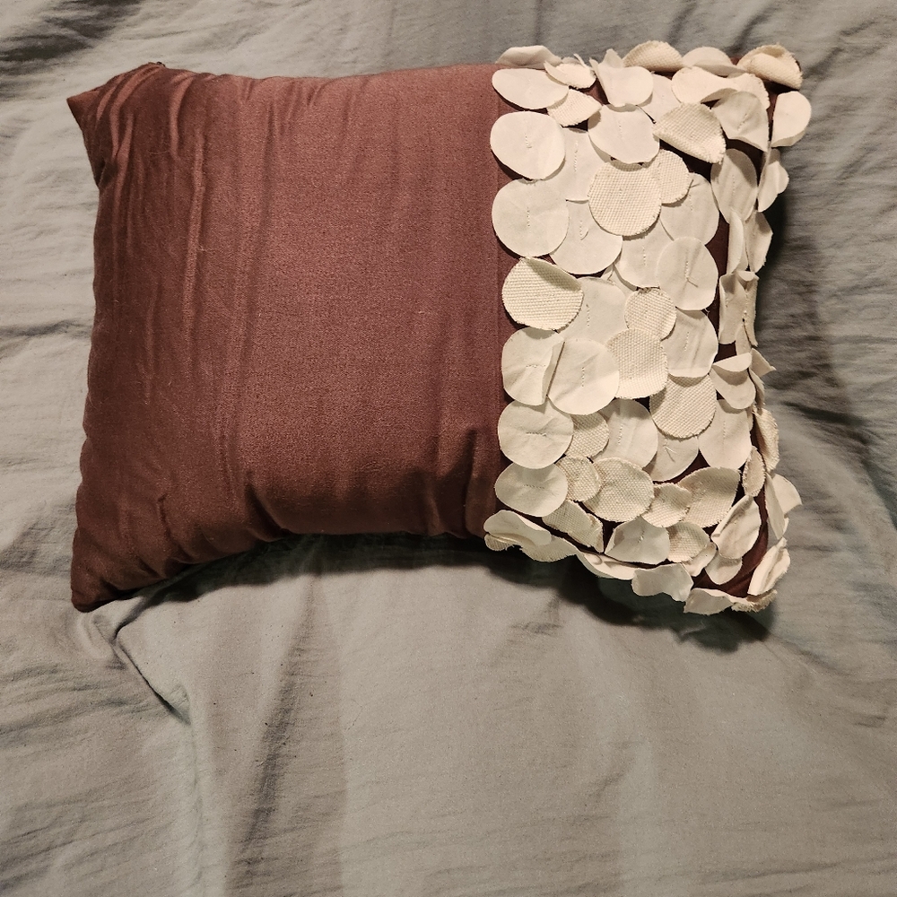Brown and white decorative toss pillow.